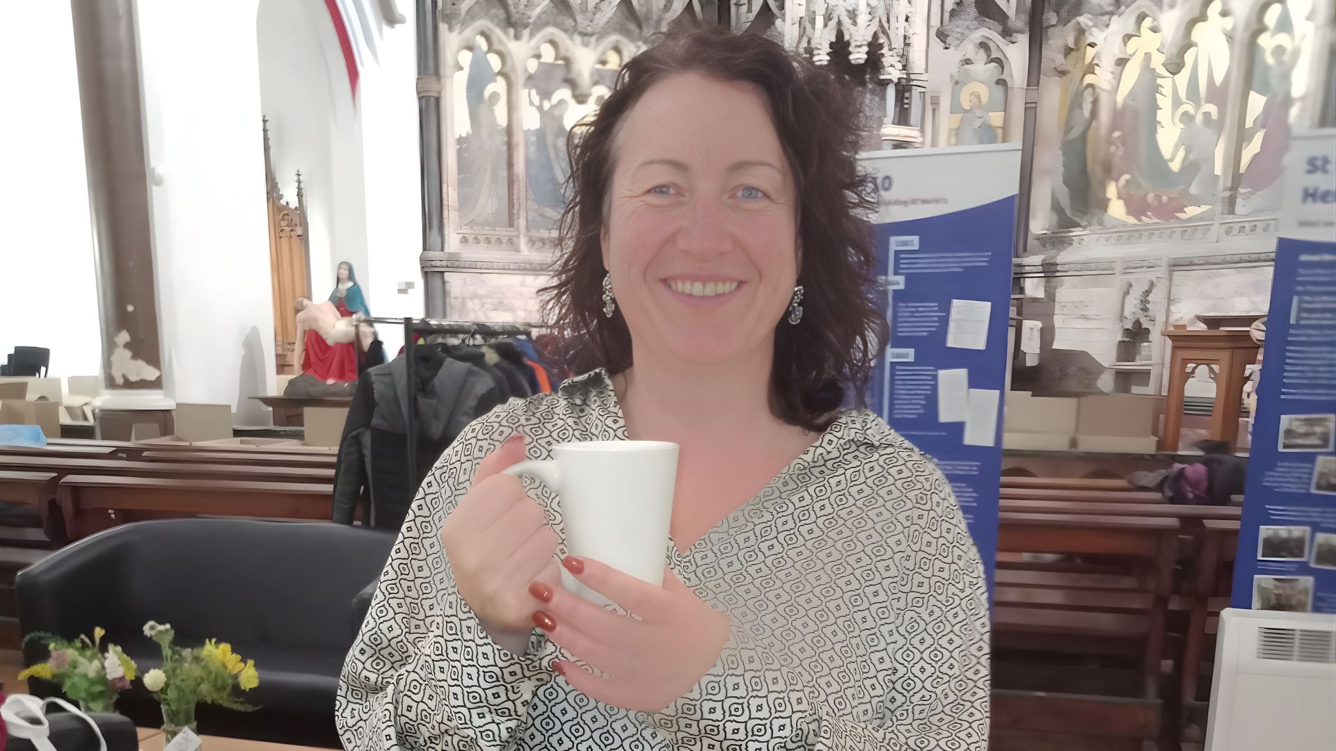 Laura Bevan smiling holding a mug of tea